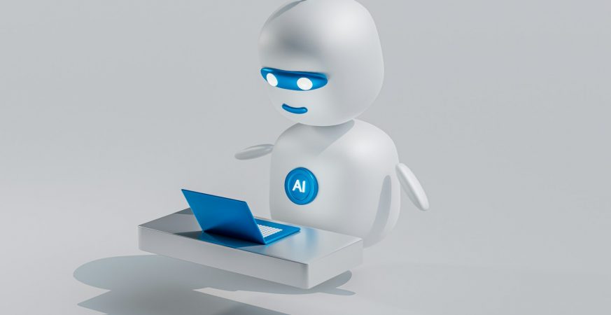 A small white robot with glowing blue eyes sitting in front of an open laptop