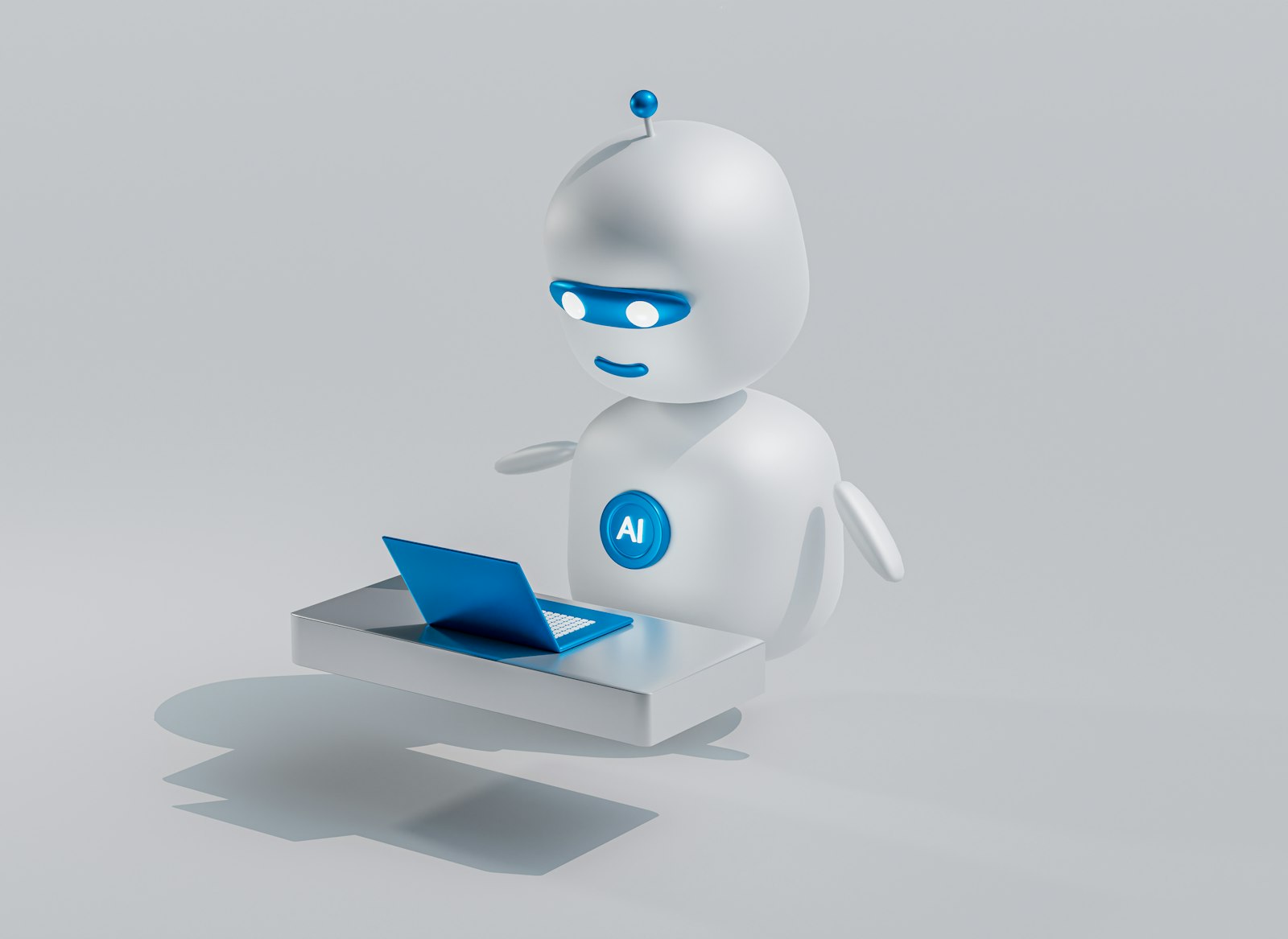 A small white robot with glowing blue eyes sitting in front of an open laptop