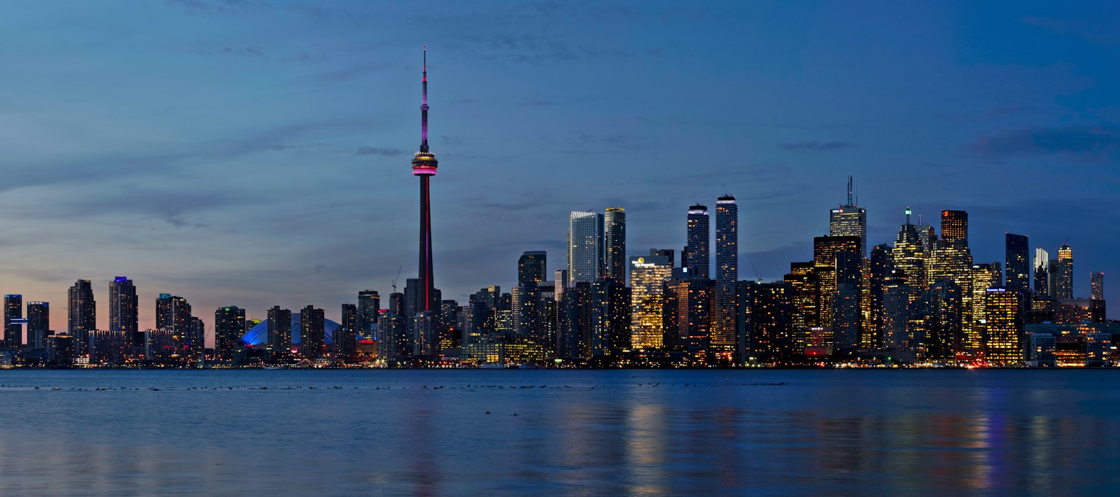 The CN Tower and illuminated downtown Toronto skyline at night, seen from the Toronto Islands