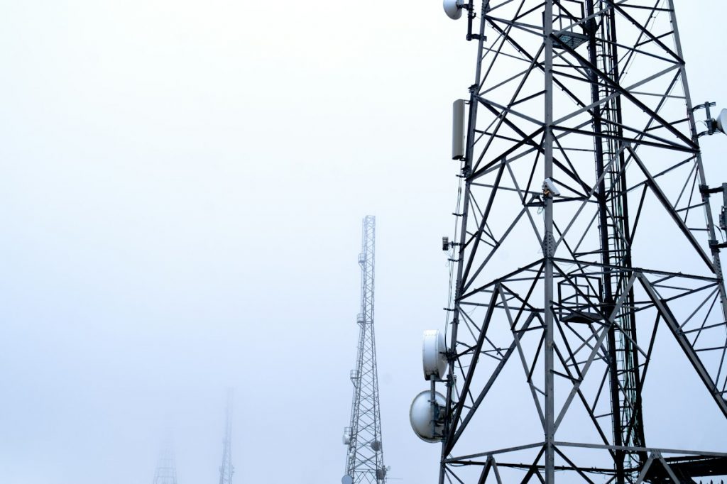 Telecommunications towers covered in antennas against the sky on Winter Hill, England