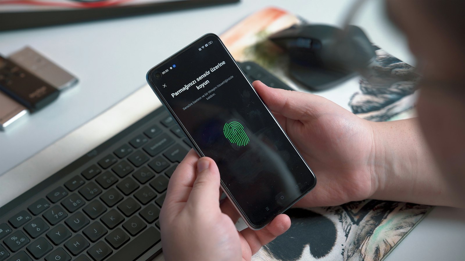 Close-up of a hand pressing a fingerprint sensor on a smartphone