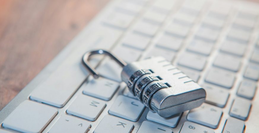 A combination padlock resting on a laptop keyboard