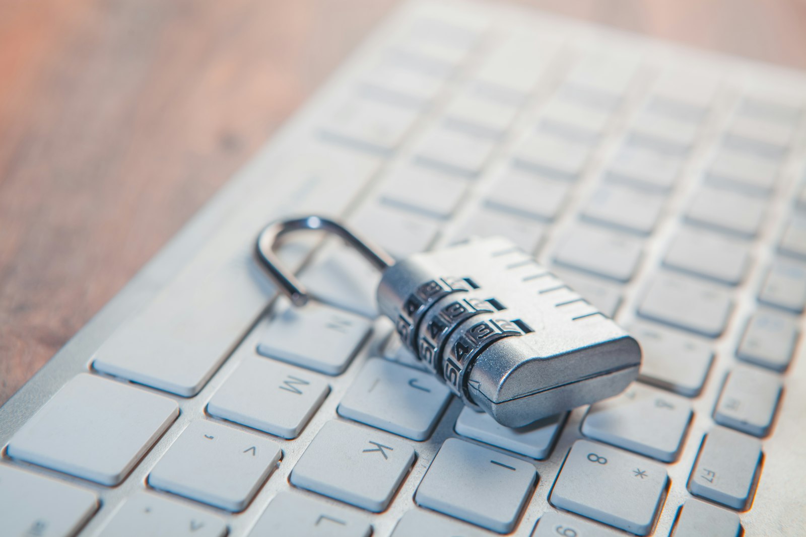 A combination padlock resting on a laptop keyboard