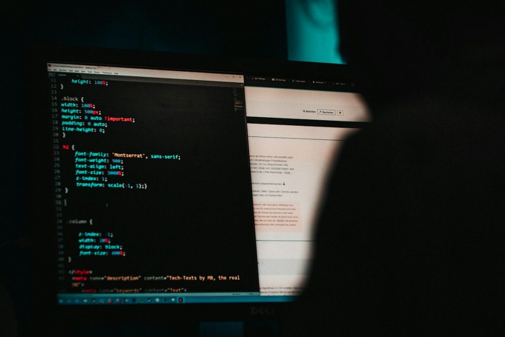 Close-up of a monitor showing lines of code on a dark background