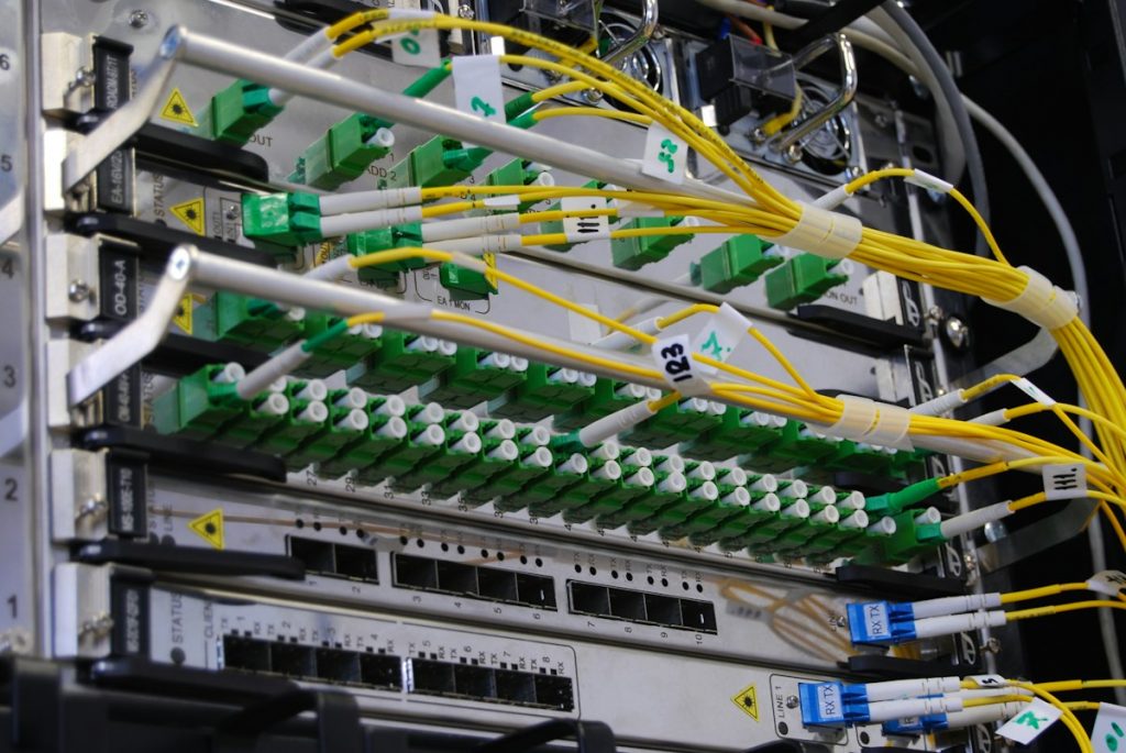 Yellow fibre optic cables plugged into a network switch in a server rack