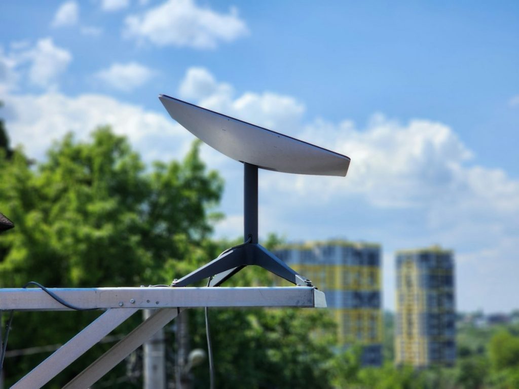 A Starlink satellite internet terminal mounted on a metal pole