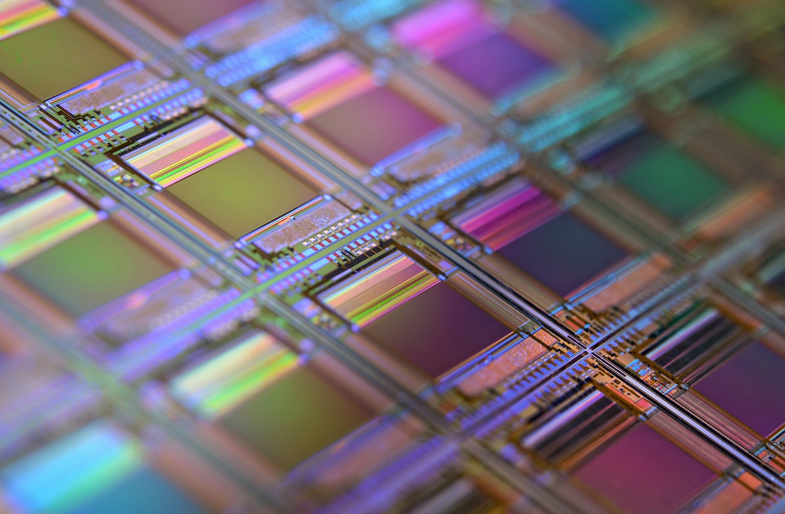 Close-up of an iridescent silicon wafer covered in a grid of microchip dies