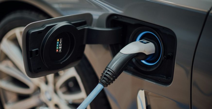 A charging cable plugged into the port of an electric vehicle