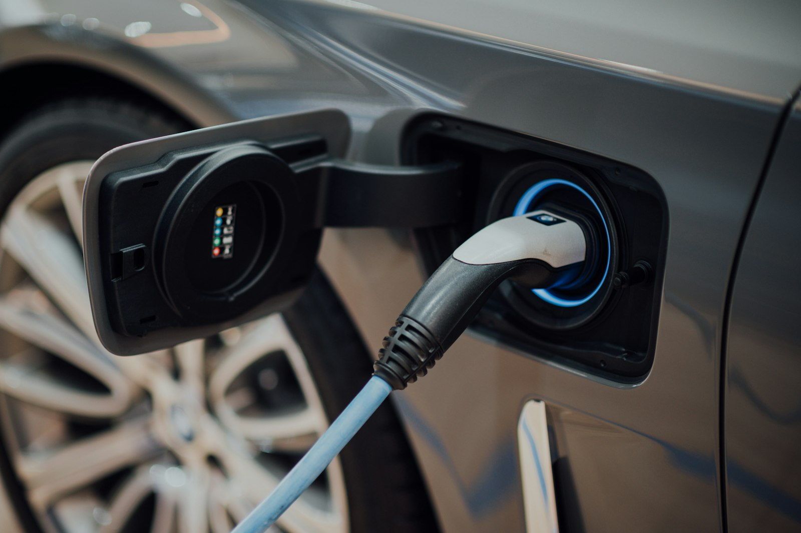 A charging cable plugged into the port of an electric vehicle