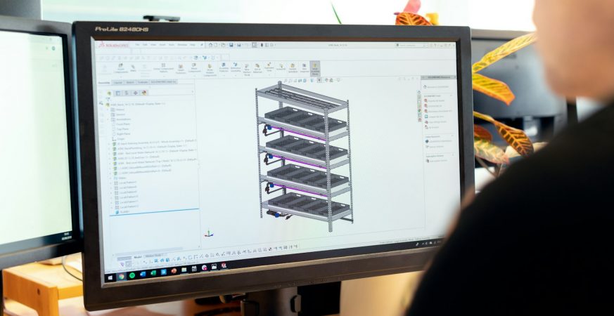 Design engineer working on a computer model at a desk, part of an R&D project