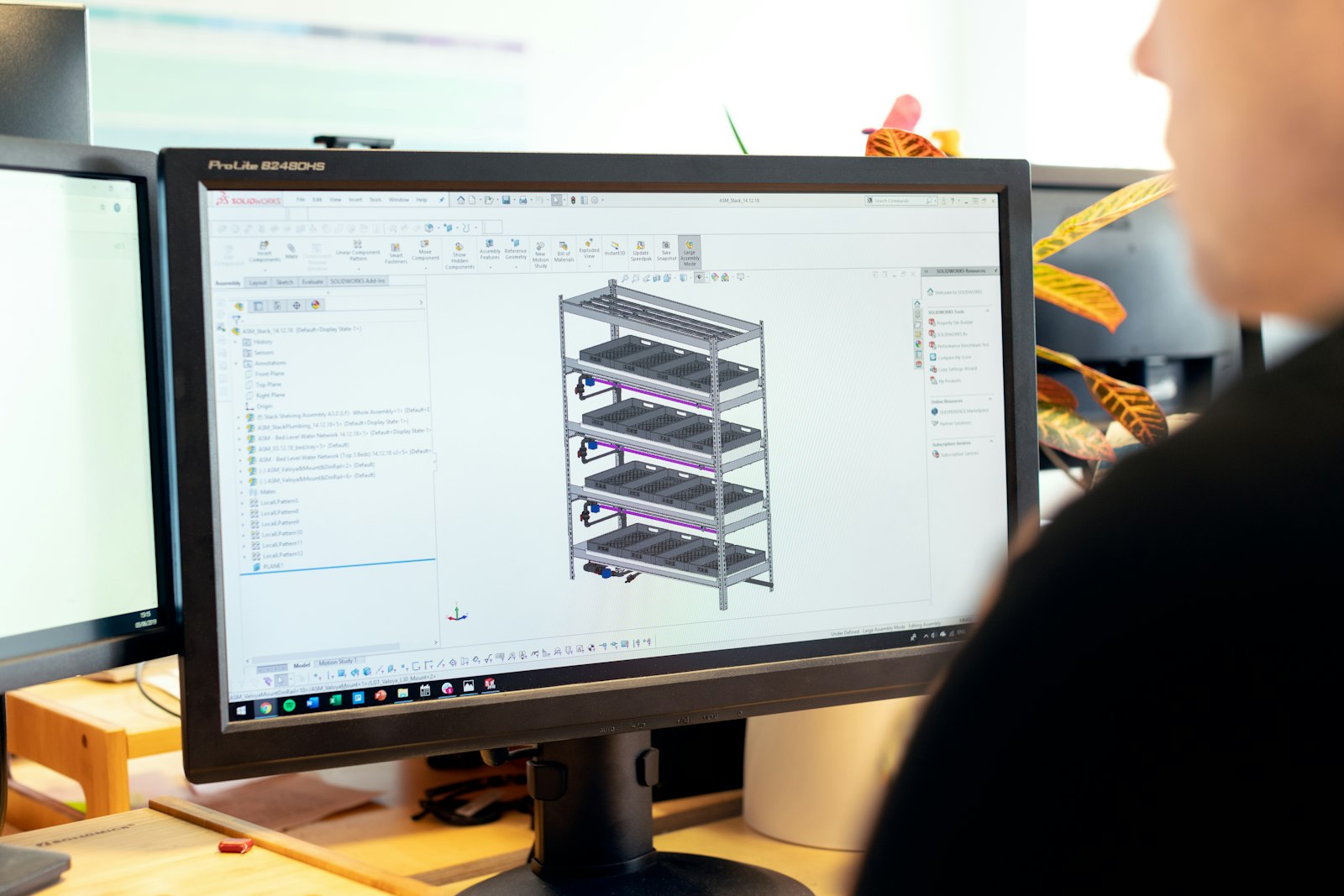 Design engineer working on a computer model at a desk, part of an R&D project