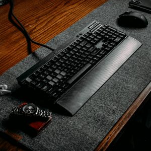 Computer keyboard resting on a felt desk pad